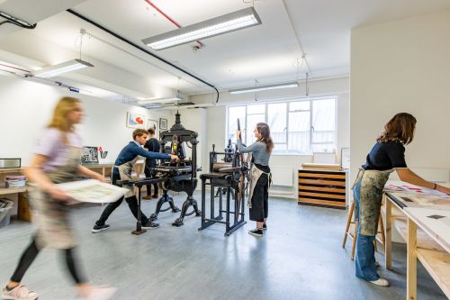 Students using a printing press  inside Central Saint Martins' Archway campus