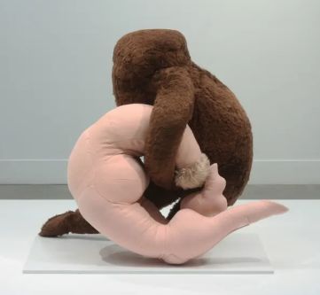 A sculpture of a furry body and a pink body embracing