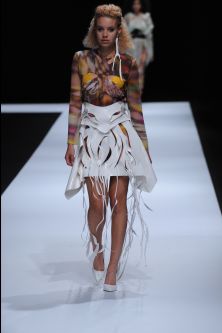 Female model wearing white skirt with geometrical shapes and colourful top designed by Nora Kim