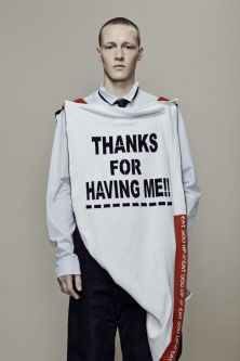 Man wearing a top with caption 'thanks for having me' in a deconstructed style