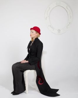 Female model sitting on chair wearing a black suit