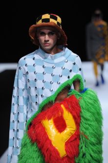 Male model wearing blue and white check sweater with green fluff and bucket hat