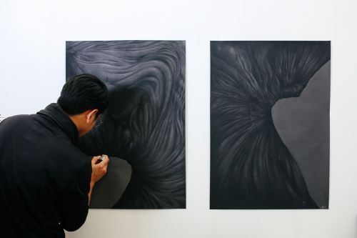 Student painting onto black canvas