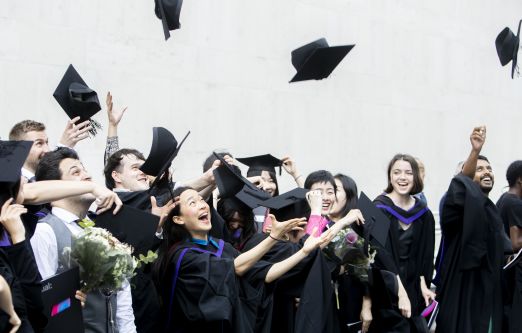 Student throwing mortarboards into the air