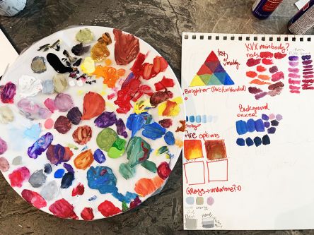 A palate of paint and paper with paint mixing exercises. 
