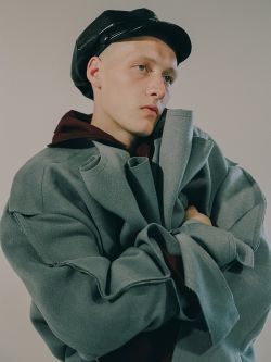 Man in a raw edge green coat