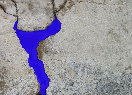Close-up of bright purple detailing in a crack in a concrete wall