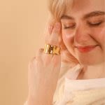 Photograph of someone modelling a crossed finger gold ring