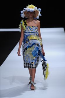 Female model with patchwork knitted dress with multiple fabrics and colours with matching hat