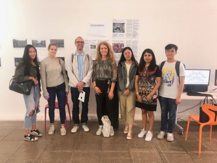 Federica with her other students and teacher with an exhibition in background