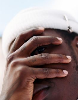 Close up shot of a man covering his face with a hand