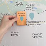 Photograph of someone holding an orange card against a map that fills the frame