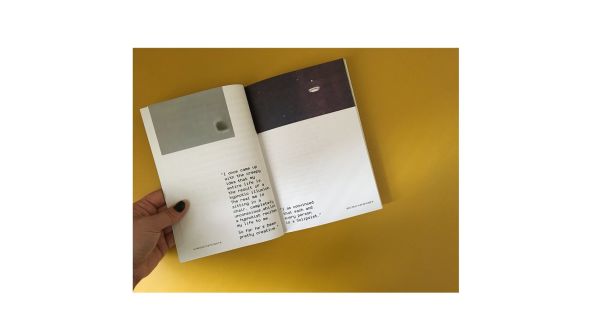 hand holds book on yellow background