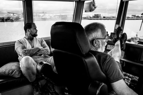 two men on chairs looking out on water