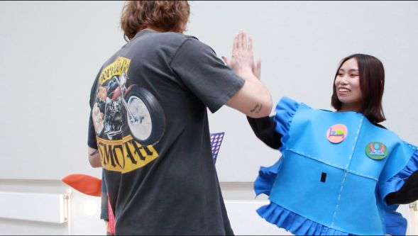 Student dressed in blue outfit high-fiving
