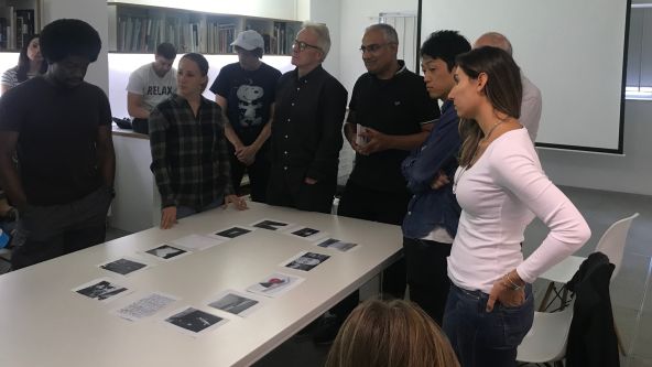 people standing around a table with images on it
