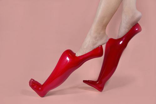Red pointed shoes on pink background