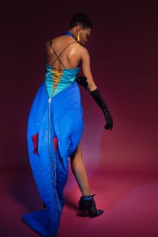 Model wearing blue dress with zip at back, made out of recycled tents