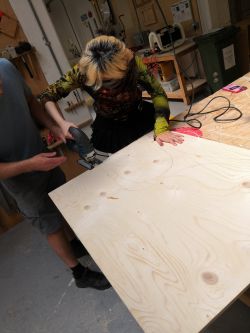 A student cutting wood in a workshop