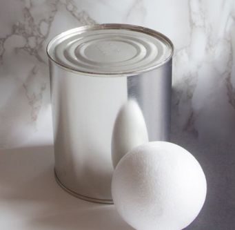 Photograph of a tin and white ball with a marble backdrop