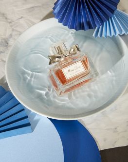 Work by Visual Merchandising - Interiors students, taken by Sarah Manning. A perfume bottle sat in a bowl of water surrounded by blue fans.