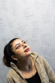 Jenny standing in front of script wallpaper