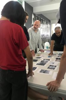 people standing around a table with images on it
