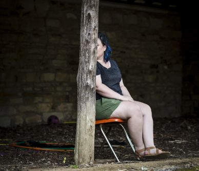 a woman sat behind a tree