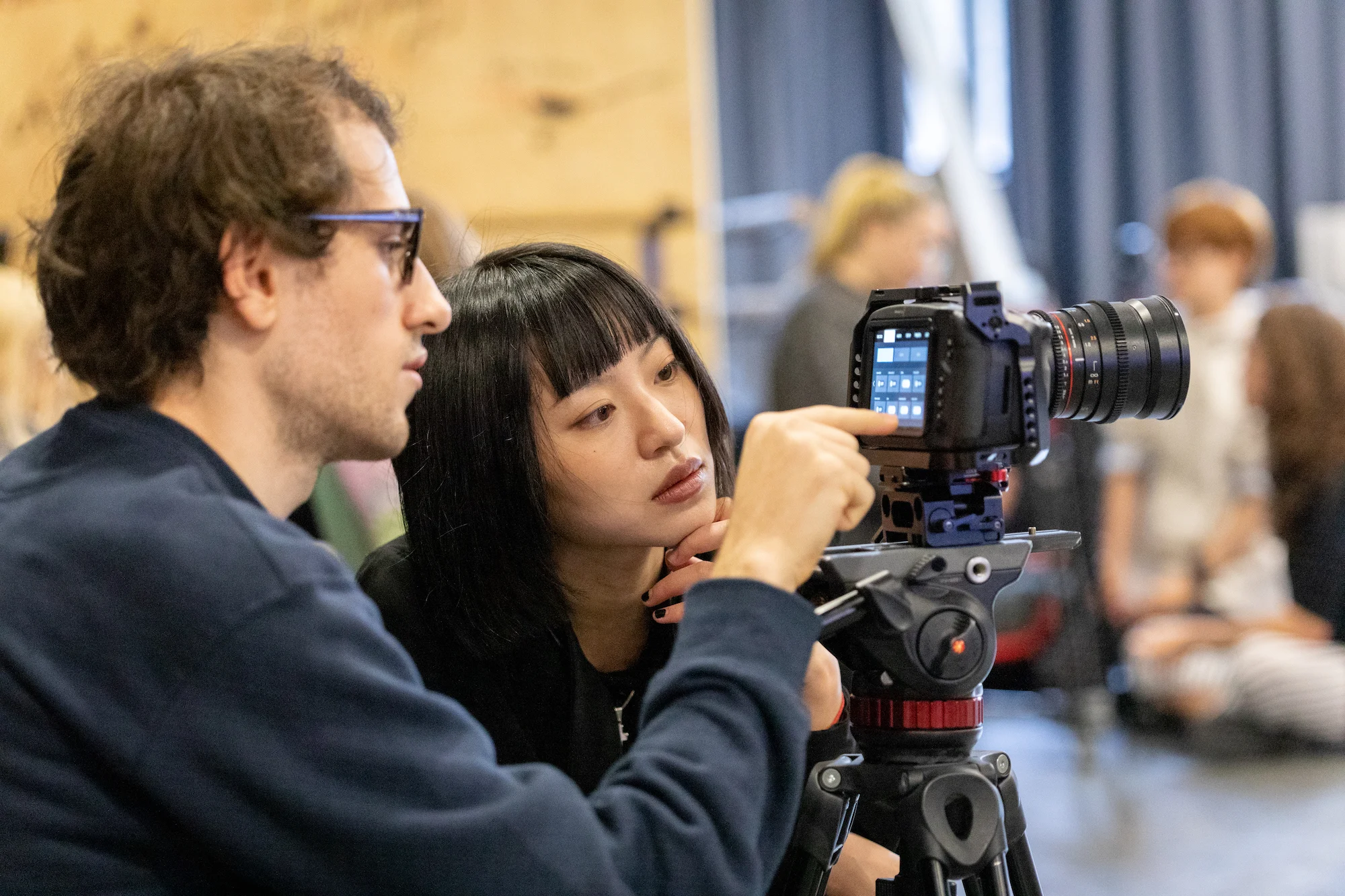 Two people looking at a camera monitor 