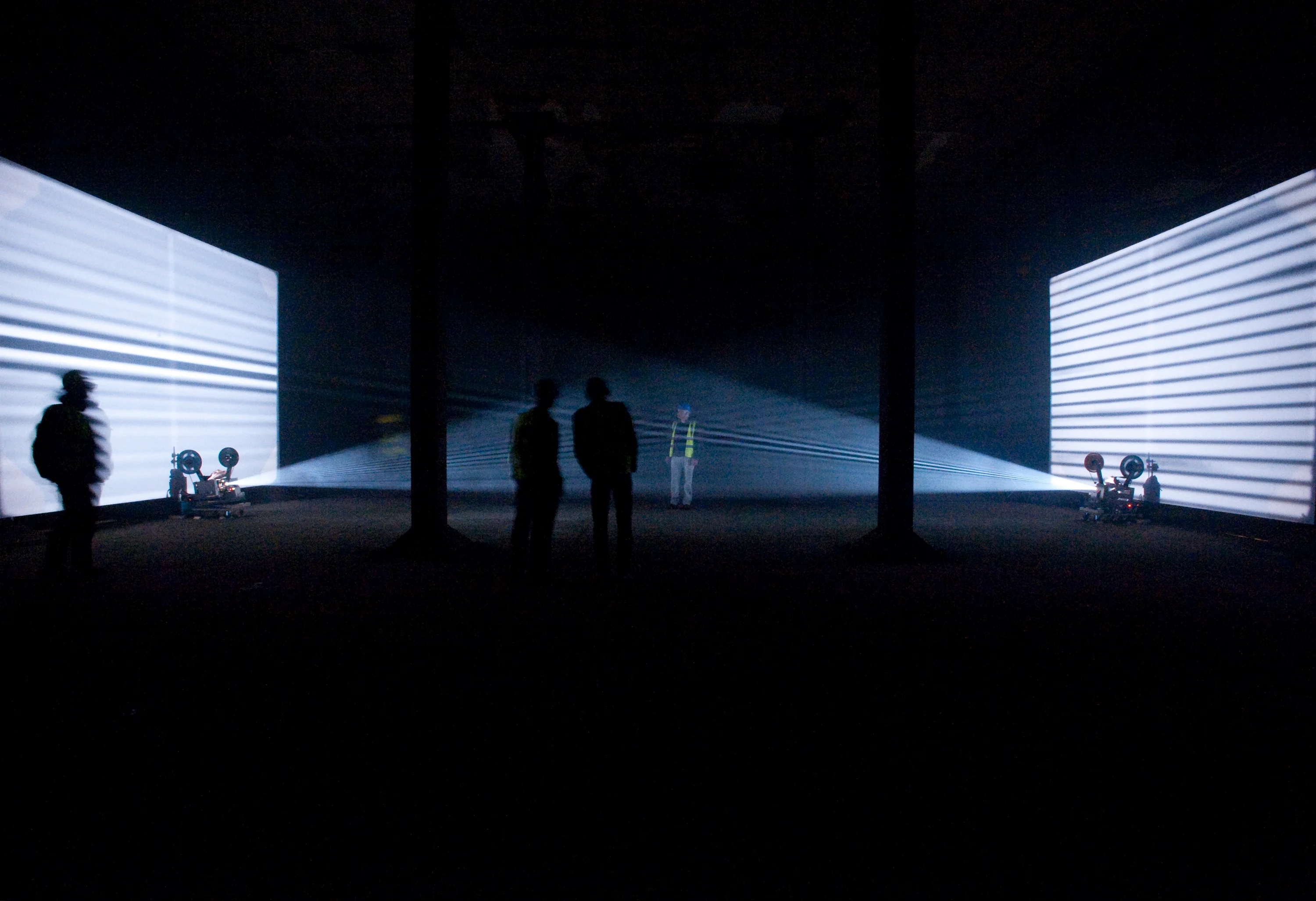 People in hi vis jackets watching a light installation