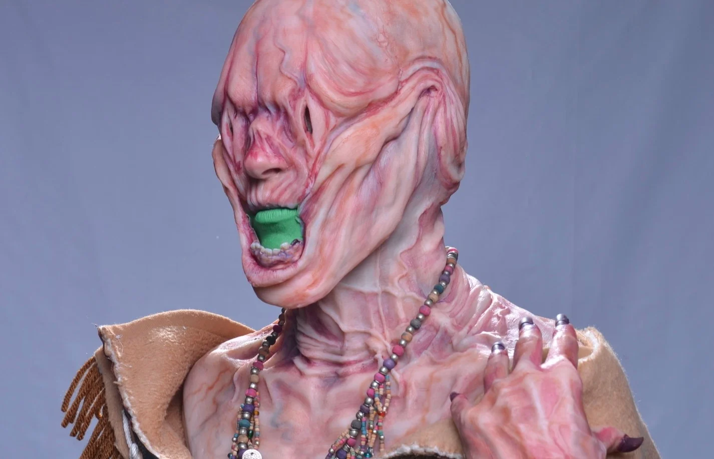Picture of the Shape Shifter, a creature covered in saggy skin and veins, dressed with traditional Inuit clothes