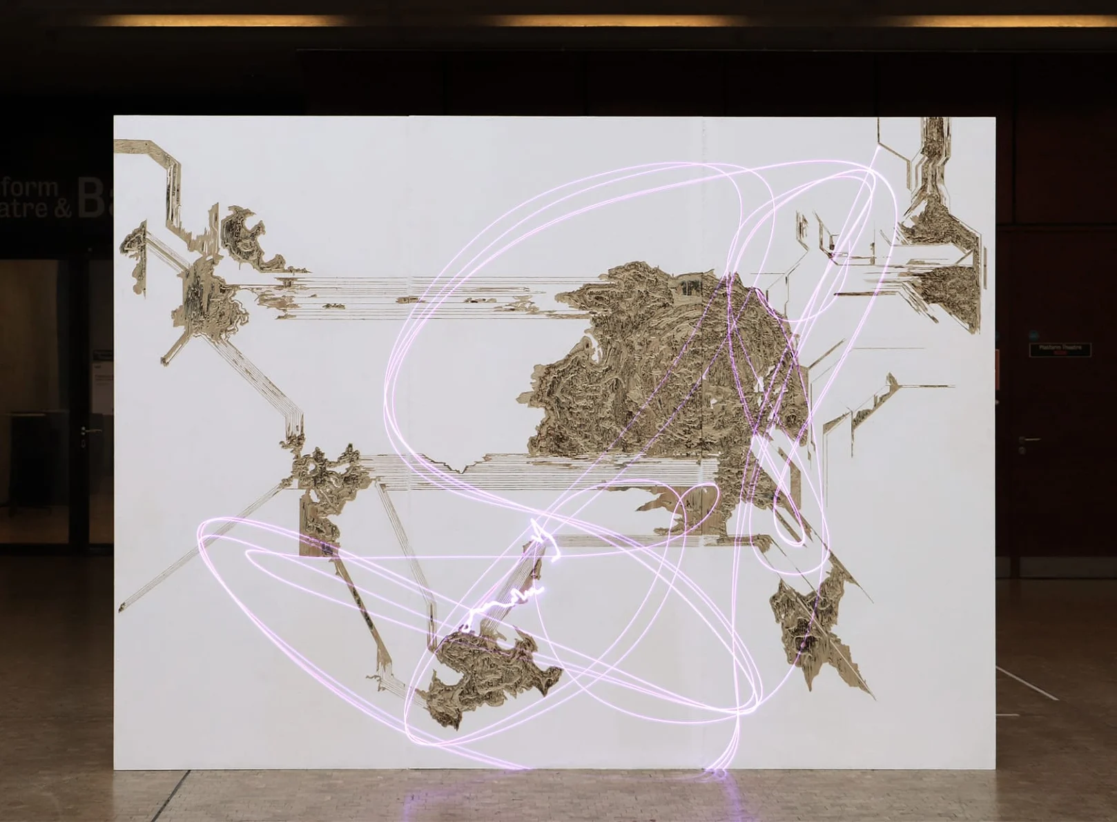 A large white screen or board with brown textured clusters representing a mapping of territories. A soft pink squiggly line is overlaid throughout
