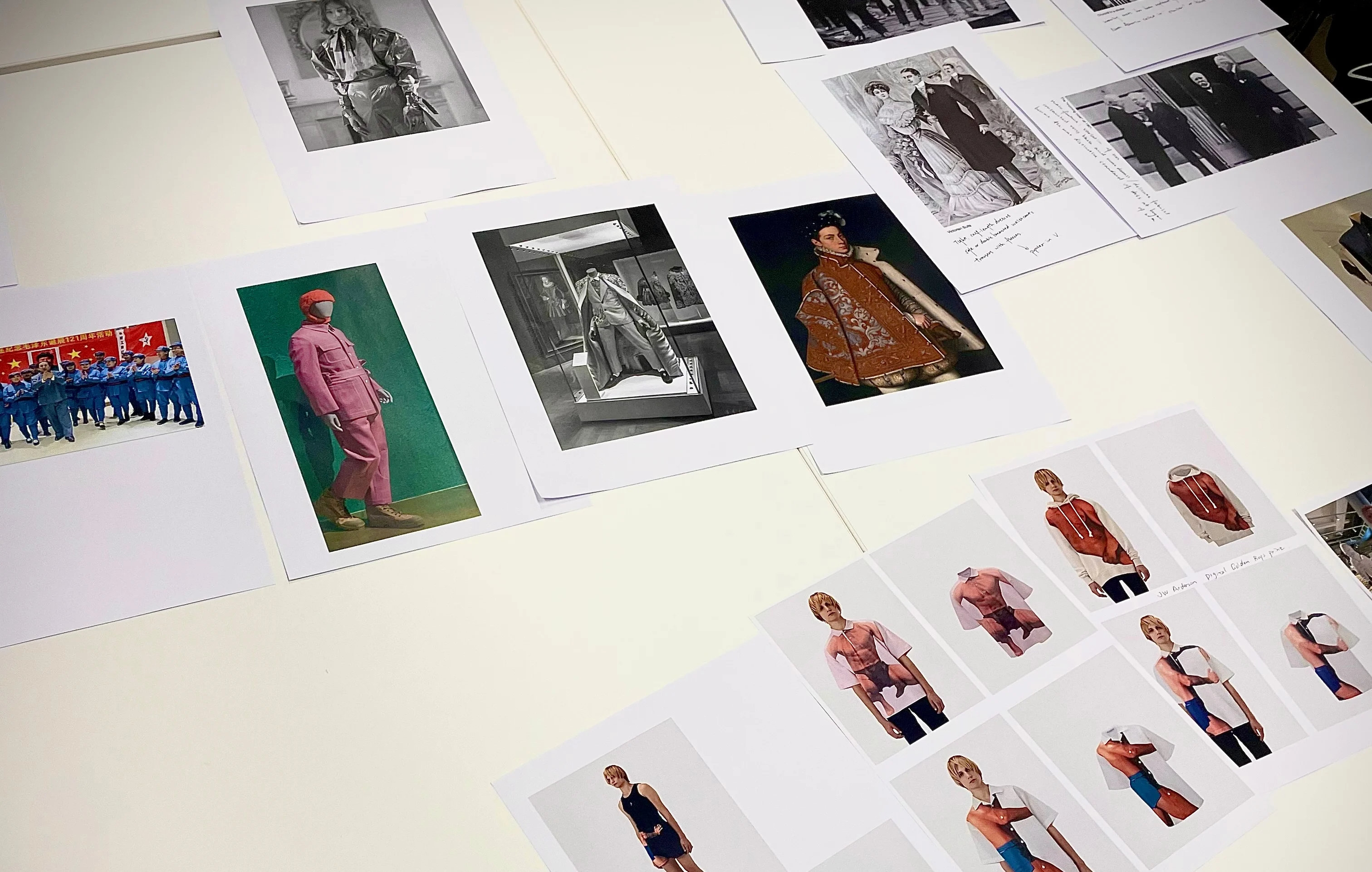Images of menswear both historical and modern day on a white table.