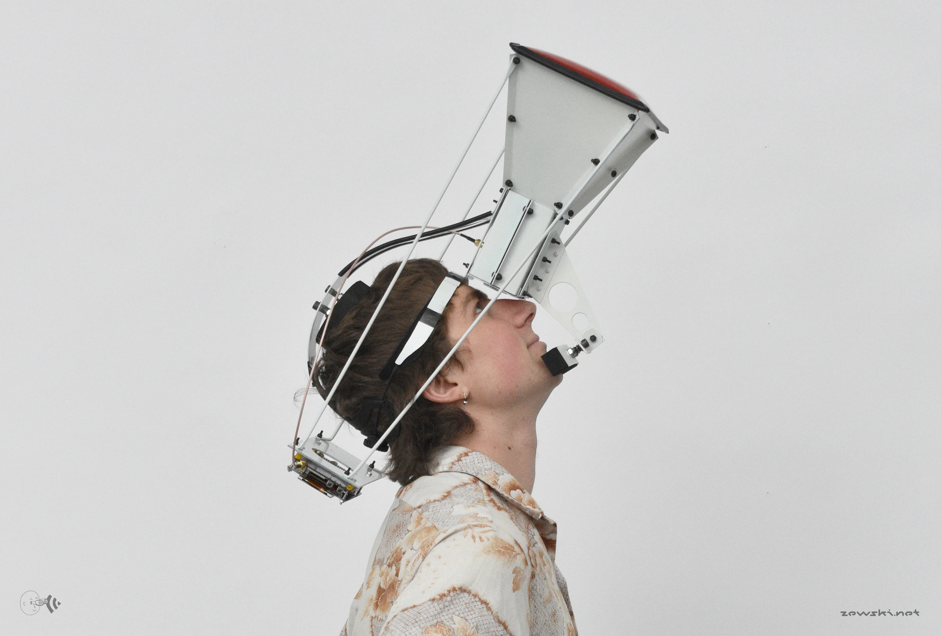 Young adult white male looks upwards into a metal construction strapped to his head
