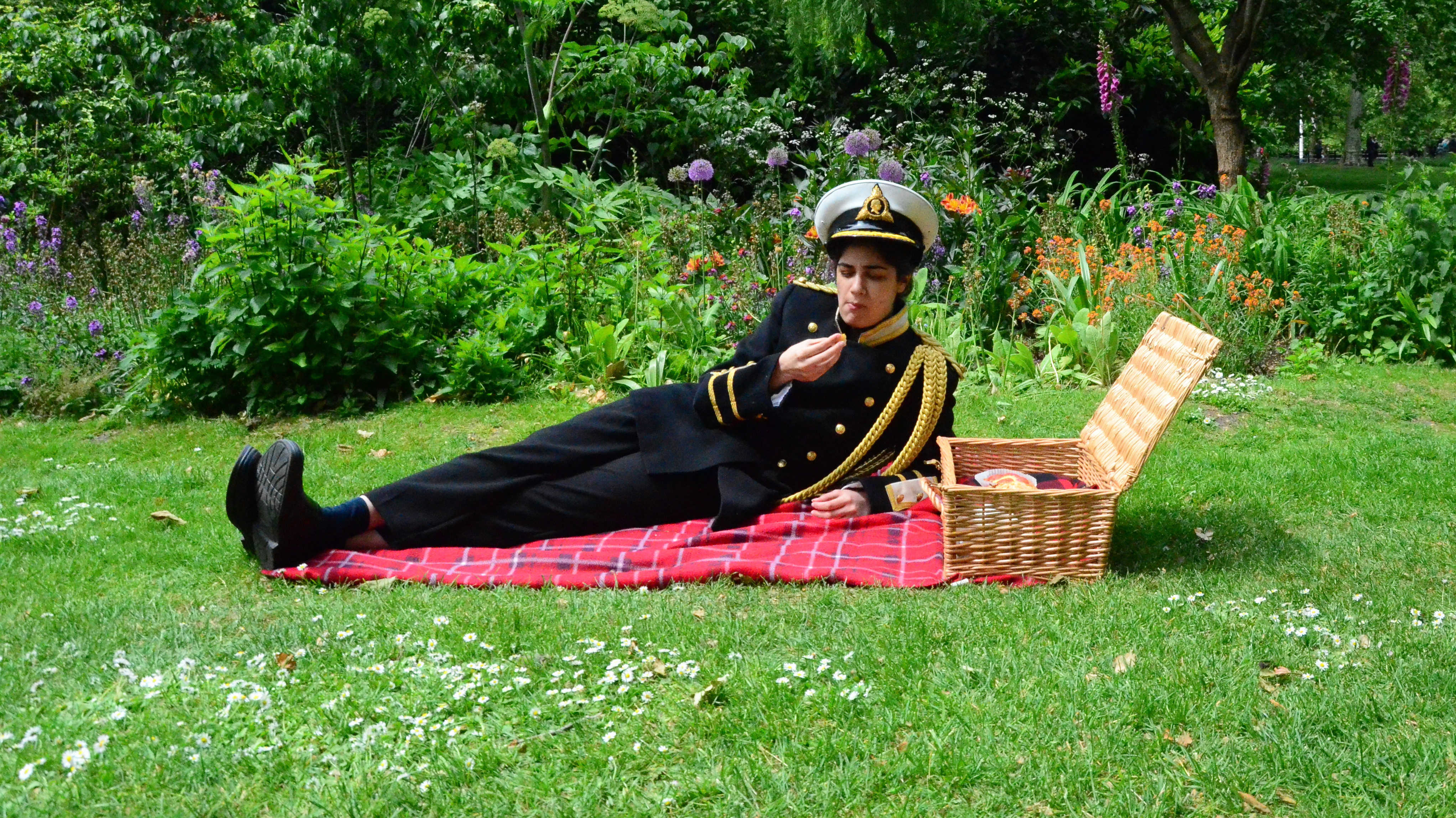 Photograph of performance in park with person in military uniform eating a picnic by Veera Rustomji - MA Fine Art.
