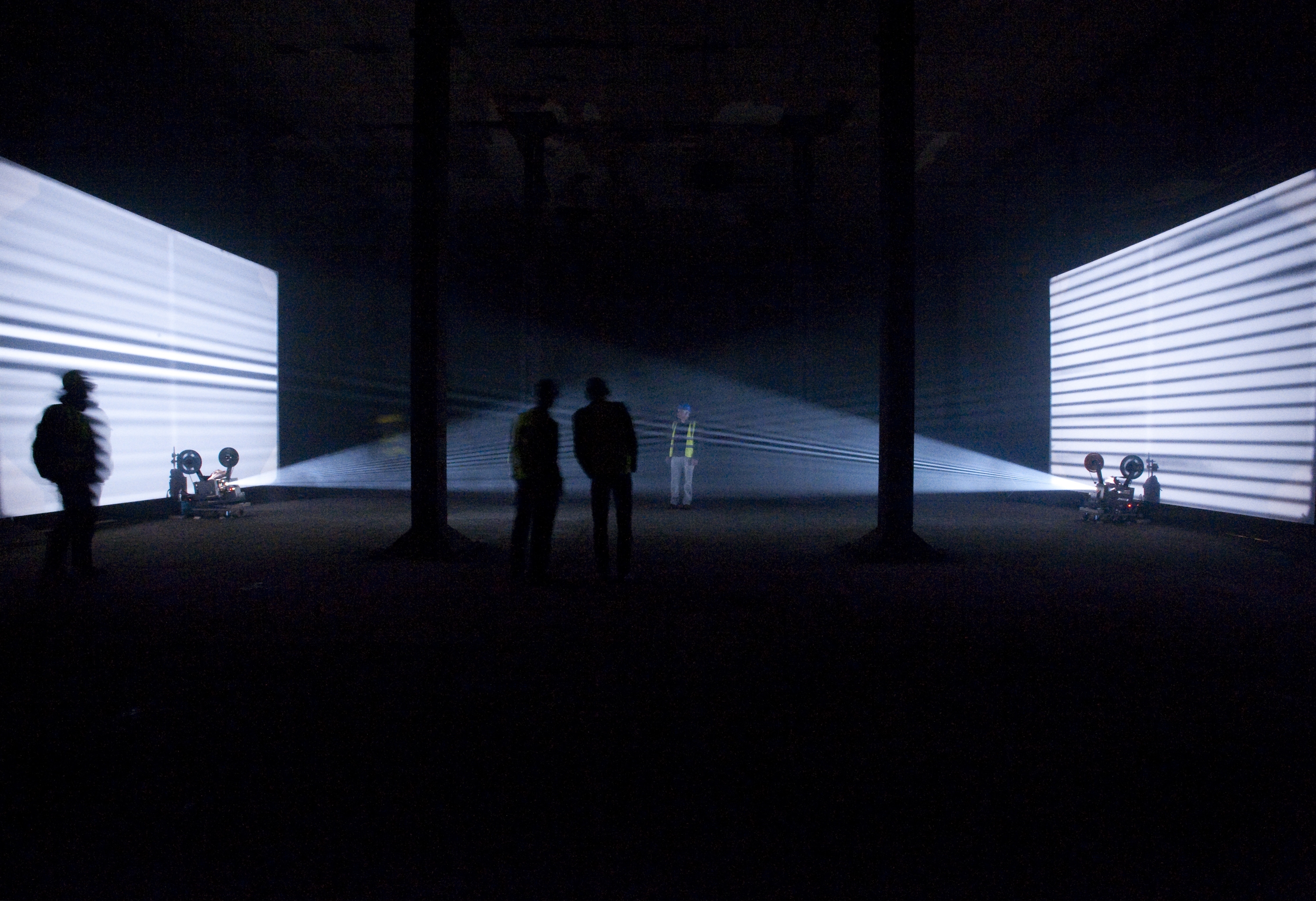 People in hi vis jackets watching a light installation