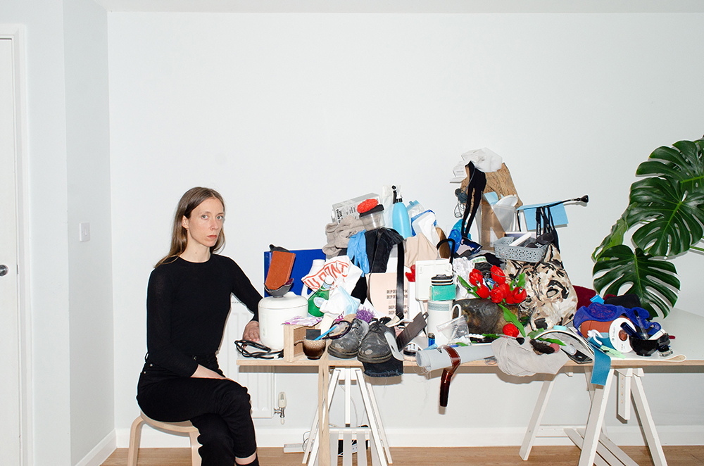 Figure sitting next to table covered with waste