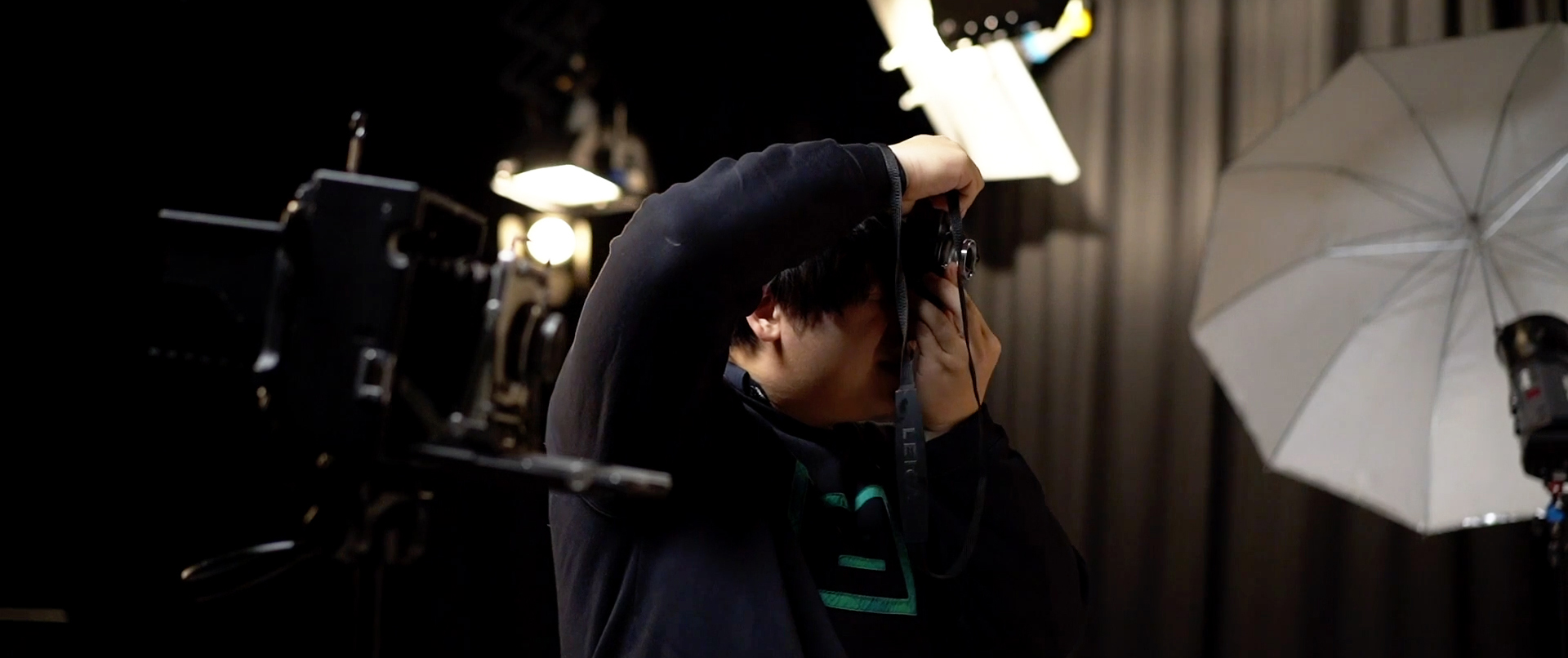 Close-up of a student holding a film camera in a studio.