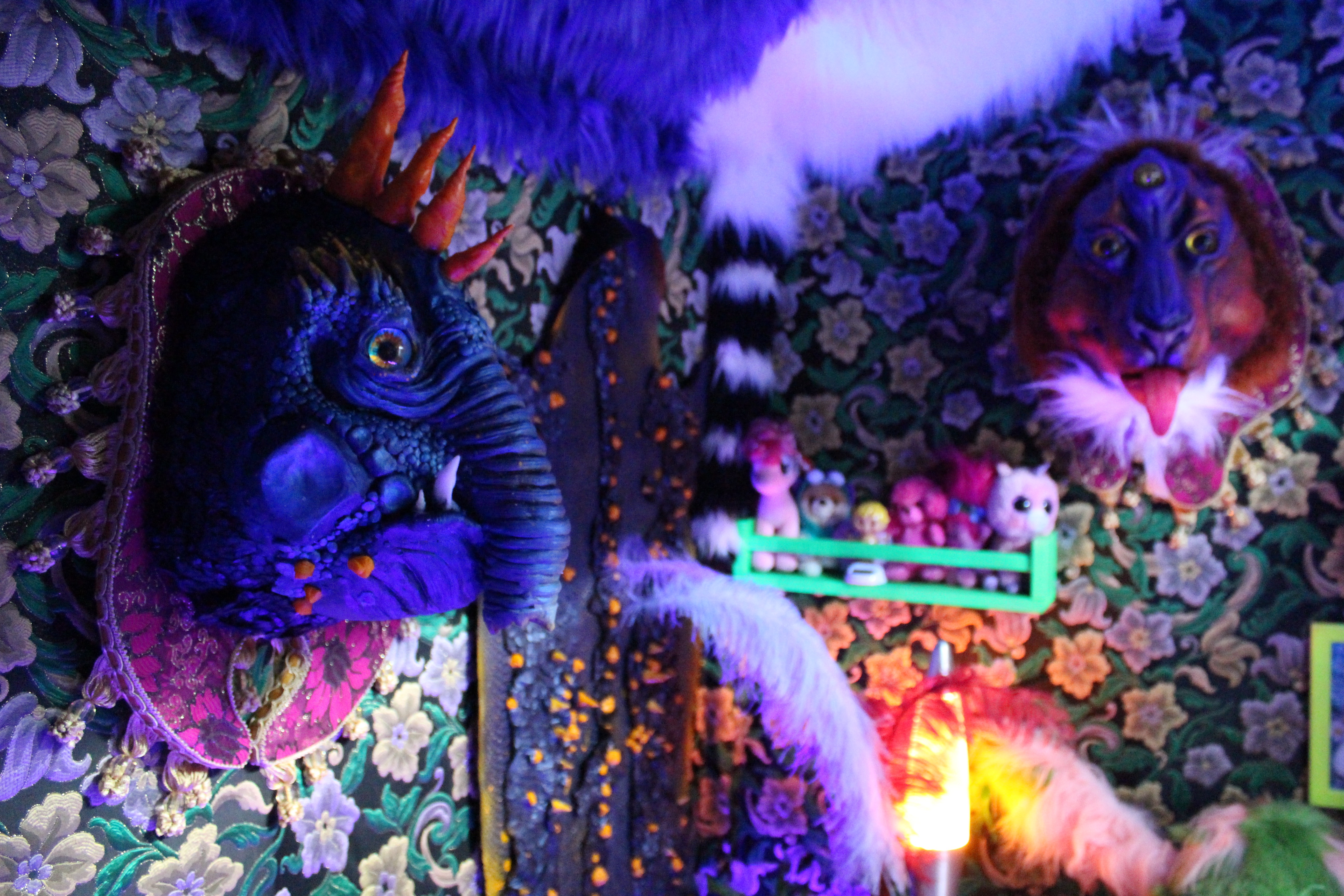 Fantastical bedroom decor full of colour, soft toys and beast-like mounted heads.
