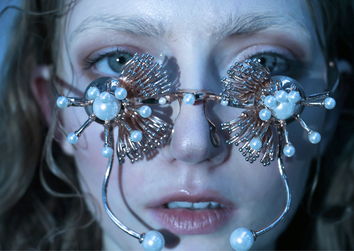 Female model wearing pearl and gold embellished glasses.