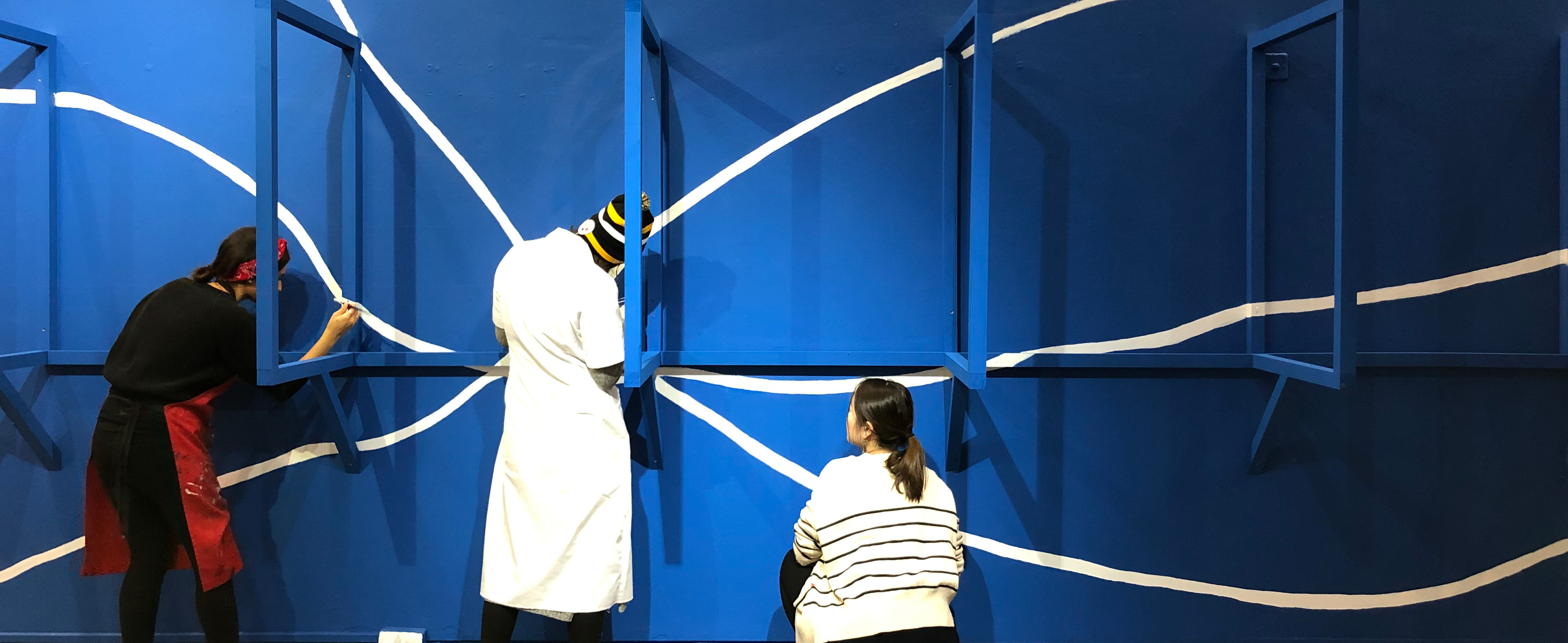 3 students installing an exhibition.