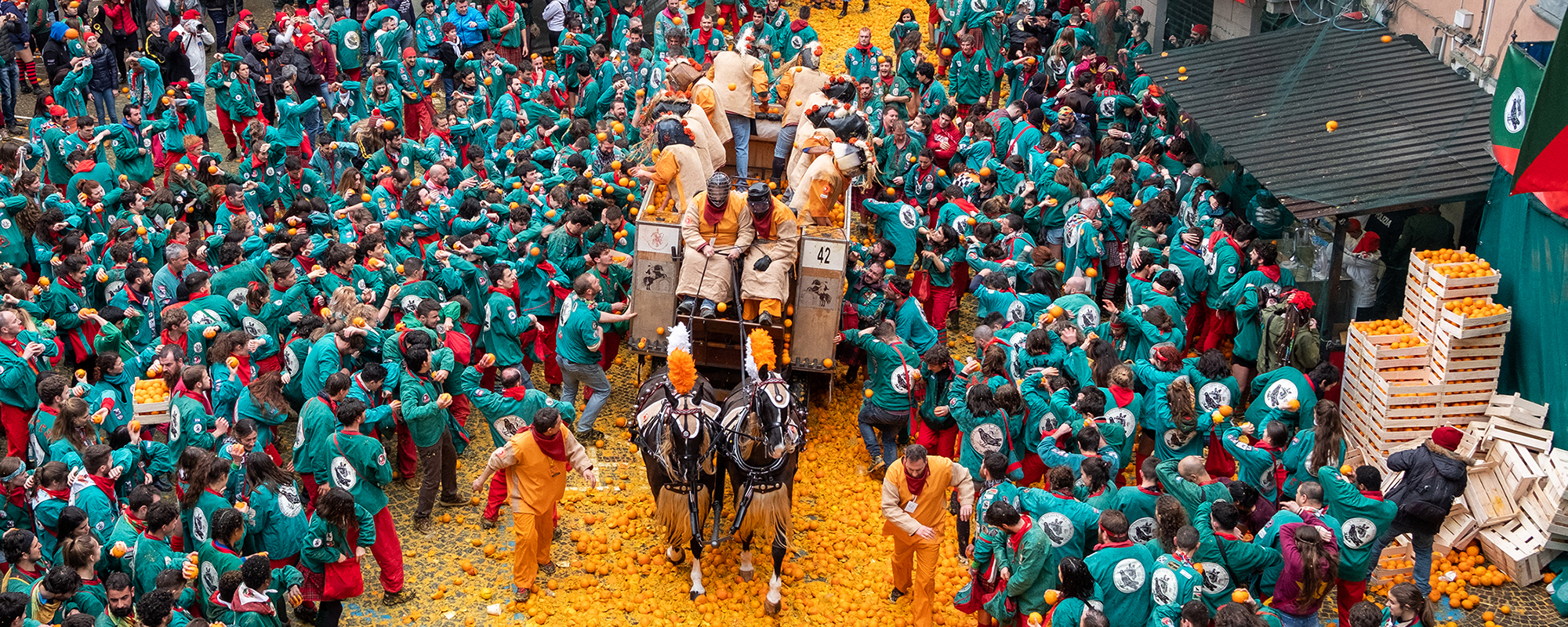 Crowd throwing oranges.