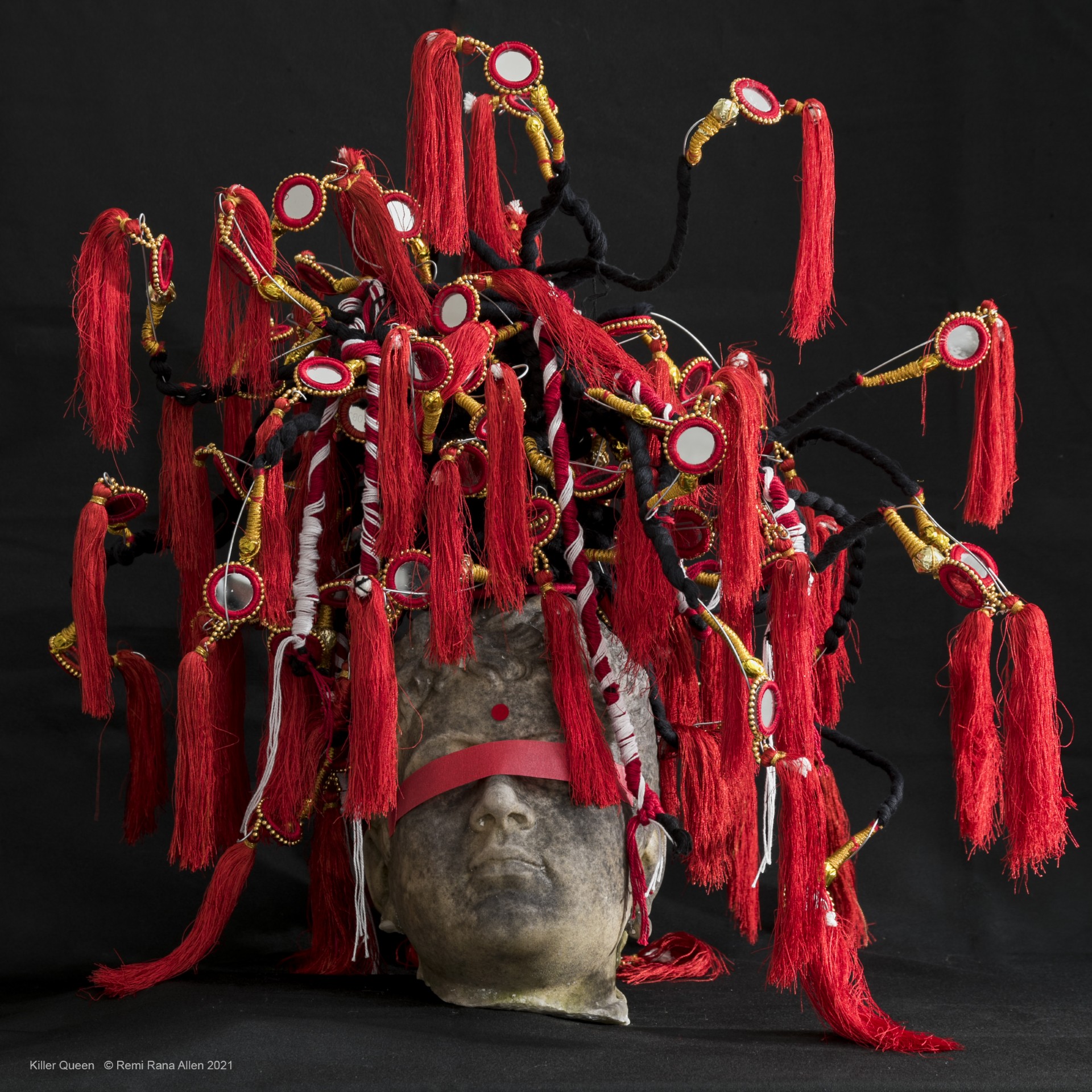 Sculpture of stone head and tassles