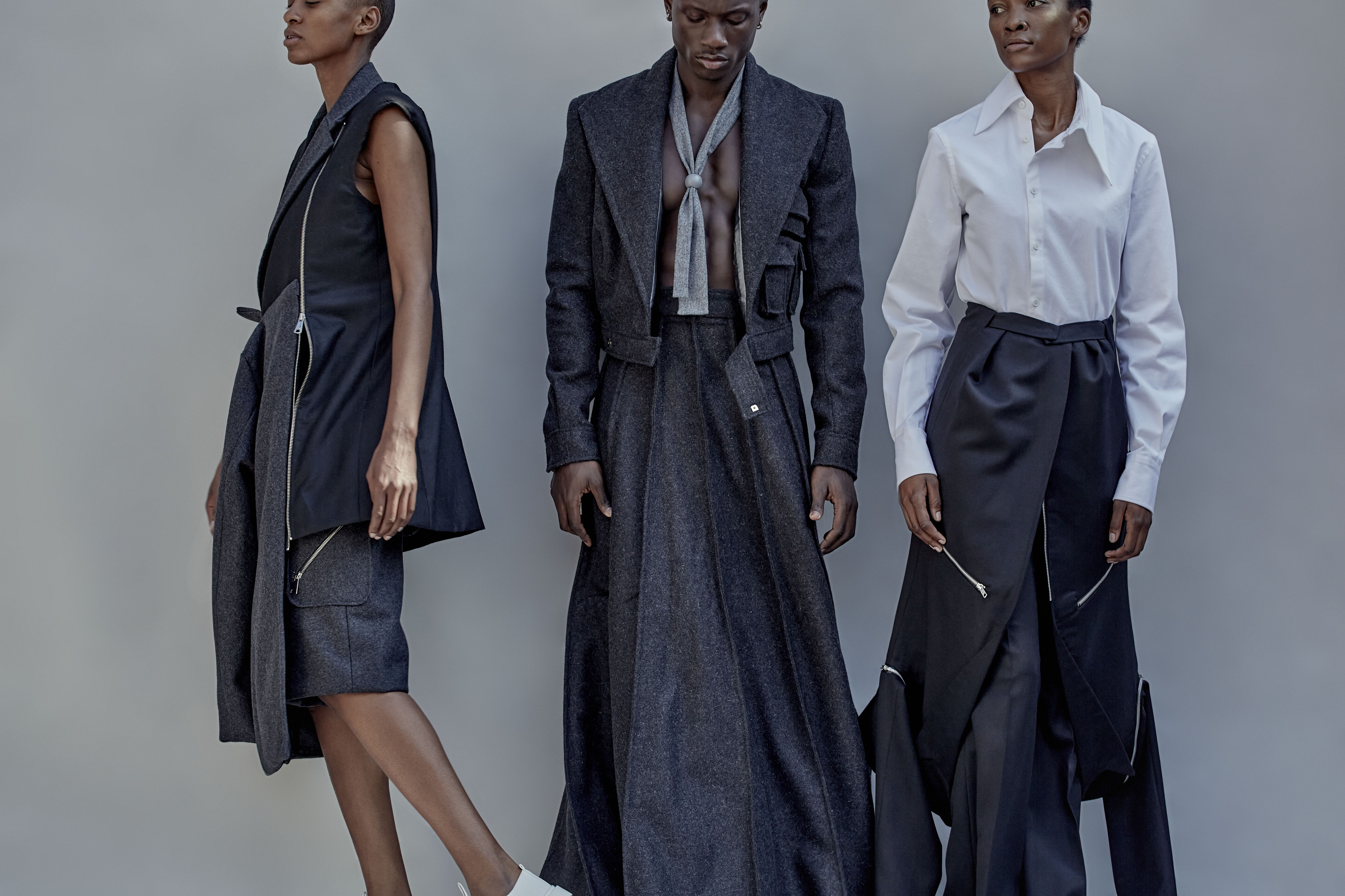 Three models in a variety of navy tailored clothing.