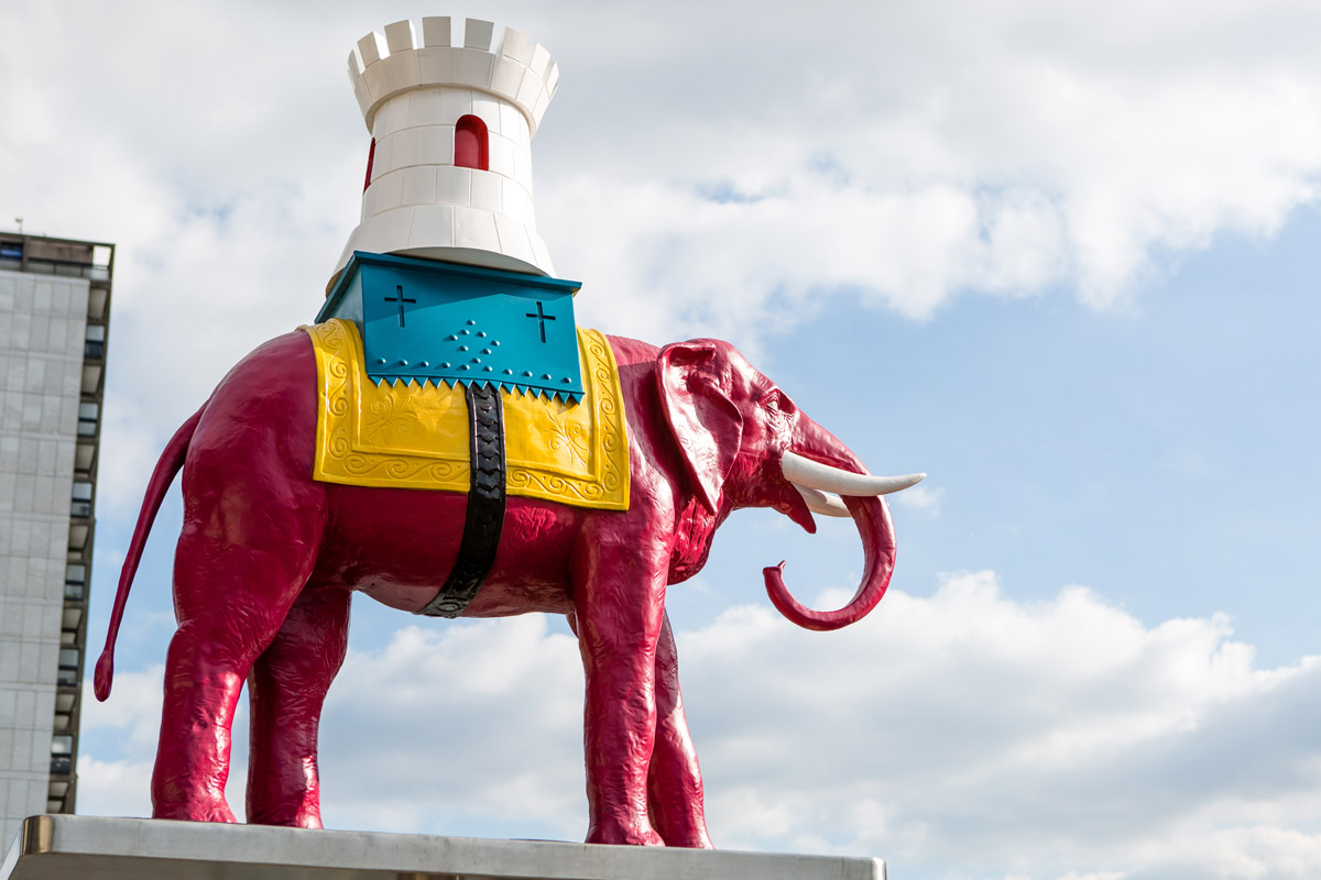 Pink elephant state with sky and clouds in background, outside Elephant and Castle station