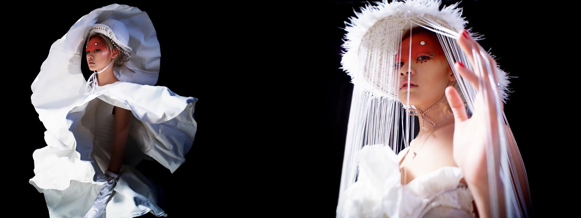 Female models posing in black background wearing white hat and dress.