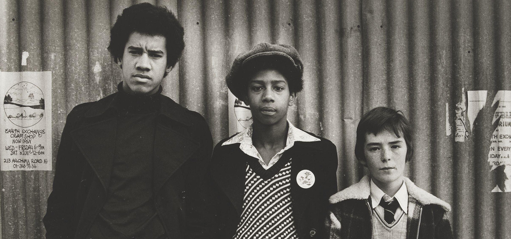 Three boys in descending height order, centre one with cloth cap