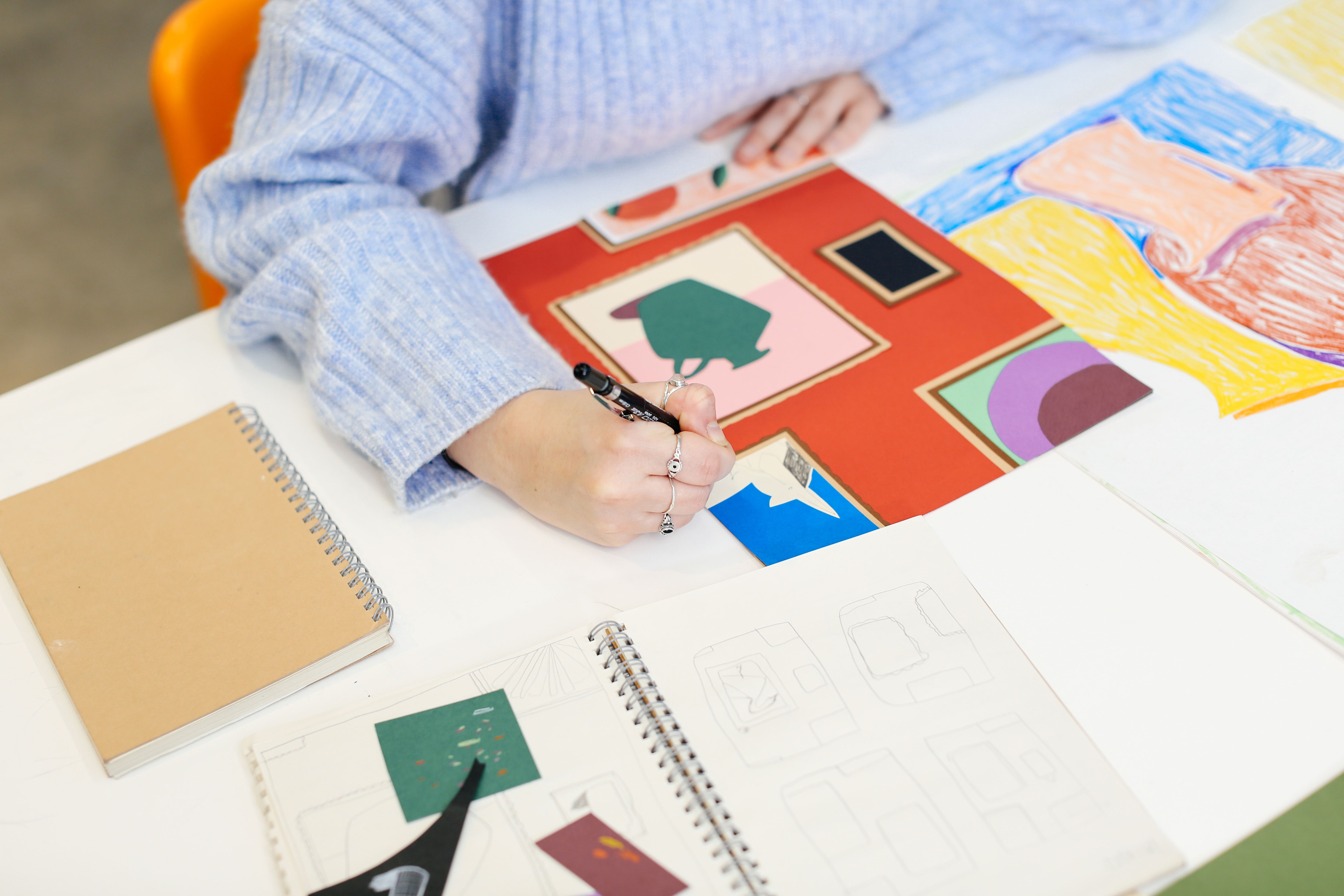 A student drawing in a sketchbook 