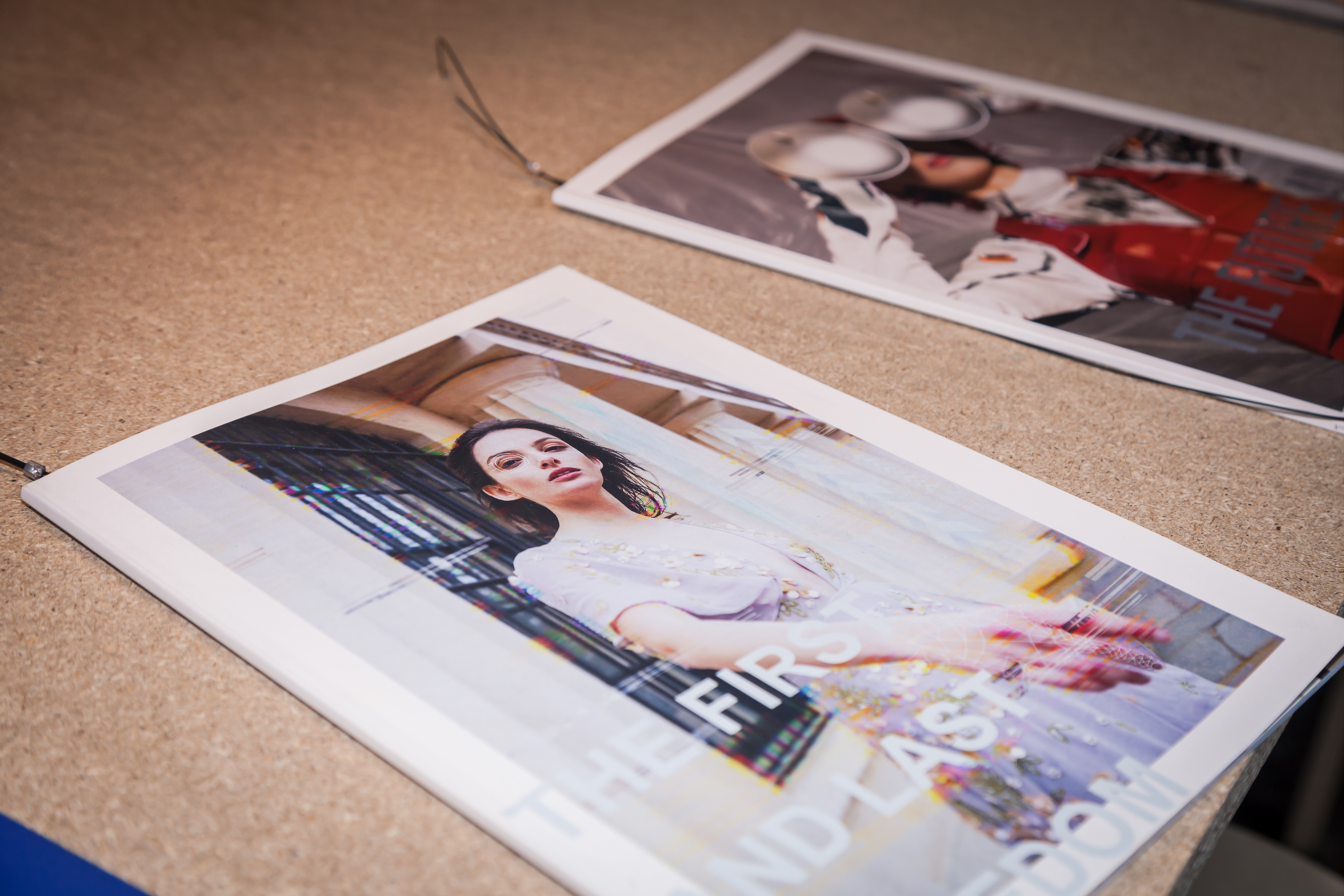 Fashion magazines attached to a cork board.