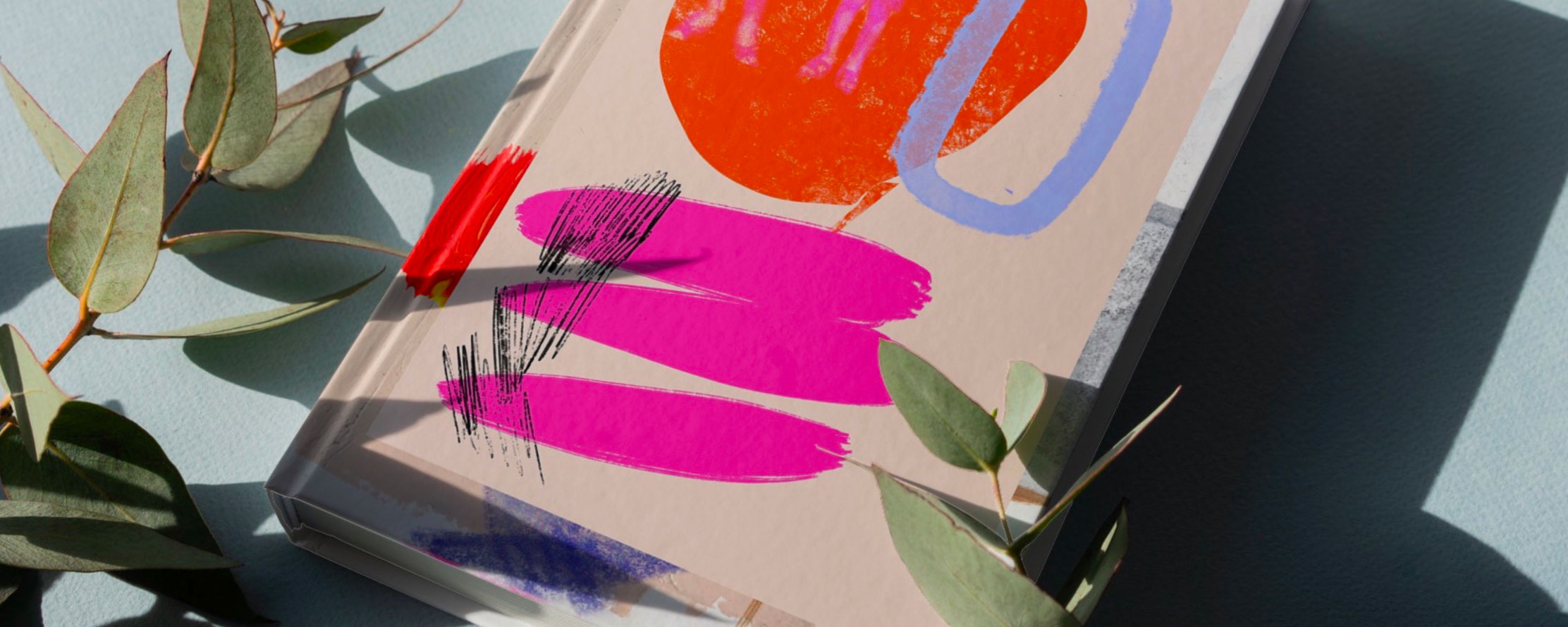 Publication with pink and orange cover, with plant.